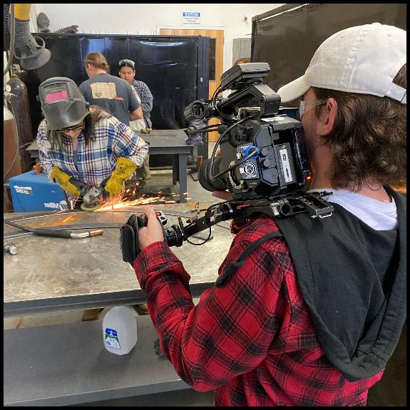 production student filming art student welding